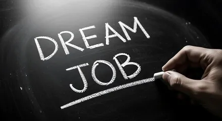 Chalk writing on a blackboard saying 'DREAM JOB'.